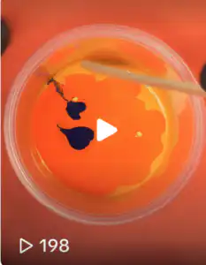 McLaren Orange (aka Papaya Orange) (3211) Top-down thumbnail of vivid orange automotive paint in a clear mixing cup, with dark pigment streaks visible as the color blends, overlaid with a play icon indicating a video of the mixing process.