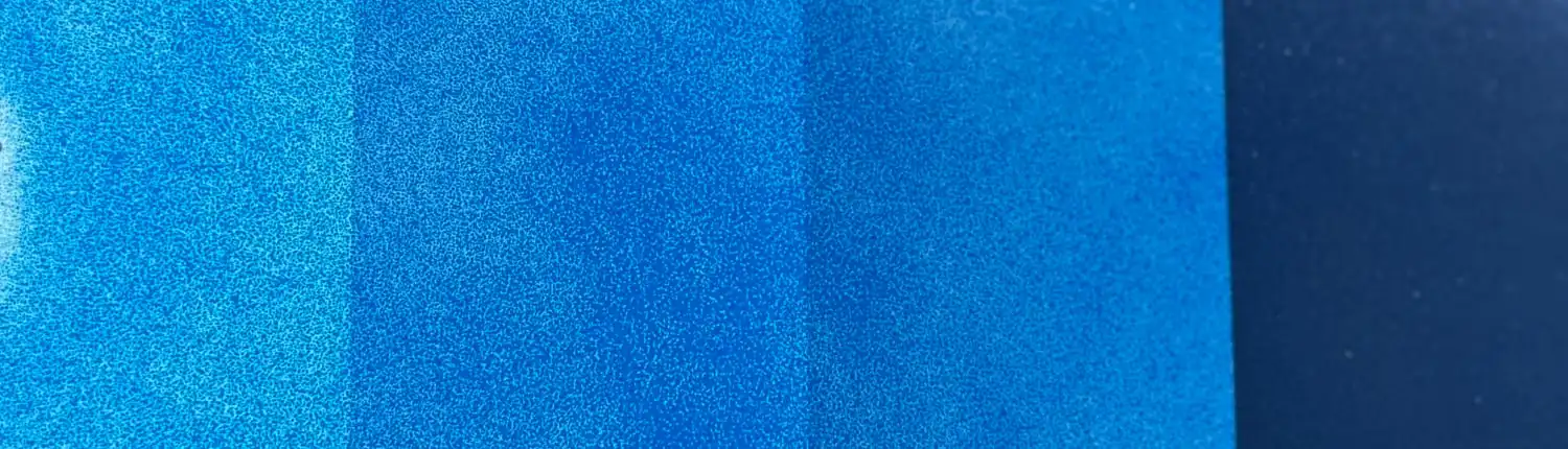 blue-paint-1-coat-1920-1080 Single coat of blue automotive paint over a test card with white, grey, and black bands showing through, demonstrating blue pigment's low hiding power.