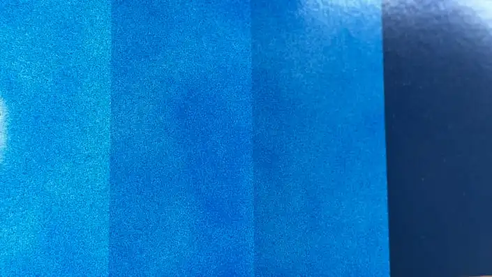 Single coat of blue automotive paint over a test card with white, grey, and black bands showing through, demonstrating blue pigment's low hiding power.