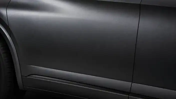 Close-up of a car door and lower body panel in deep matte gunmetal gray with a velvety non-reflective finish, echoing Acura's Gotham Gray Matte, illustrating the depth of premium multi-layer automotive paint.